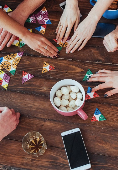 groep mensen speelt samen een kleurrijk bordspel aan tafel van bovenaf gezien